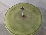 a small table with a green top and a black shoe next to it