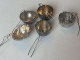 cinq cuillères en argent posées sur une surface blanche