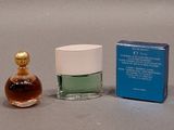 a small bottle of perfume next to a small box of perfume