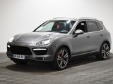 Une Porsche Cayenne grise est garée sur un sol à damier