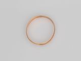 gros plan d'une bague en or sur une surface blanche