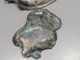 two pieces of metal sitting on a table next to each other