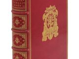 un livre rouge avec des bordures dorées et un emblème doré sur la couverture