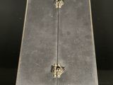 a silver box with two doors and two handles on a black surface