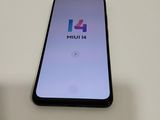 the back of a black phone with a logo on it sitting on a table