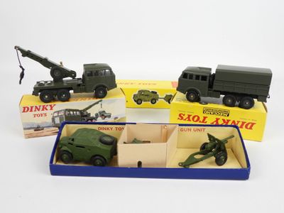 trois véhicules militaires miniatures dans une boîte posée sur une surface blanche