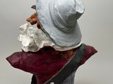 a sculpture of a woman with a hat on top of it