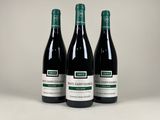 trois bouteilles de vin posées sur une table blanche