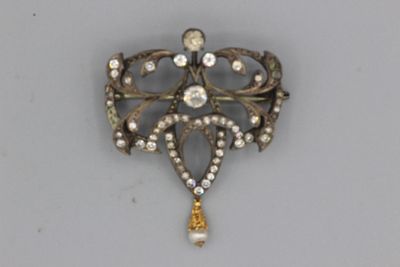une broche en or sertie de pierres blanches et jaunes