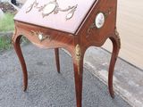 a small wooden desk with a clock on it