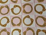 a lot of gold rings on a pink and white checkered table cloth