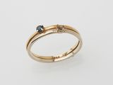 a yellow gold ring with a blue sapphire and a diamond