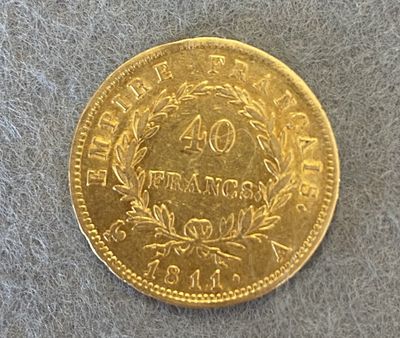 gros plan d'une pièce d'or sur une surface grise