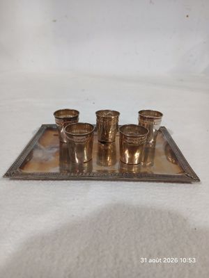 un plateau en argent sur lequel sont posés cinq verres