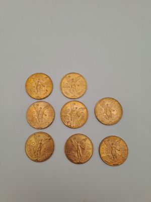 un groupe de pièces d'or posées sur une surface blanche