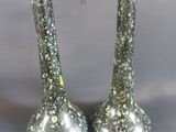 deux vases en argent posés l'un à côté de l'autre sur une table