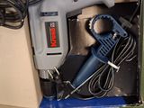 a box with a drill and a cord in it