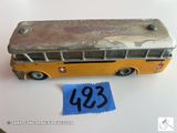 un petit bus en jouet posé à côté d'une feuille de papier