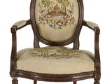 une chaise dont le dossier est orné d'une tapisserie