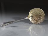 une cuillère posée sur une table, dans laquelle se trouve une autre cuillère