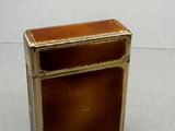 une petite boîte en métal avec un couvercle marron posée sur une table