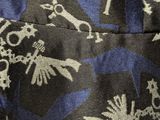 a close up of a blue and black tie with skulls on it