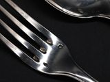a fork and a spoon on a black table