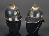 two helmets with gold accents on the sides of them on a mannequin head
