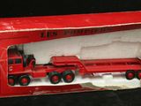 un camion jouet rouge dans une boîte rouge sur fond noir