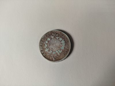 une petite pièce sur laquelle figure le portrait d'un homme