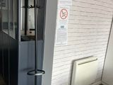 un porte-manteau dans un coin de la pièce, avec une pancarte accrochée au mur