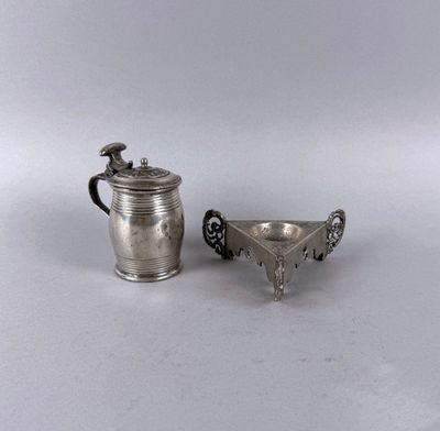 a small silver cup and a small silver cup on a white surface