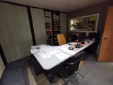 une table sur laquelle sont posés des papiers, avec une chaise devant