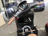 a motor scooter parked in a garage with other scooters in the background