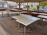 des tables et des chaises sur la terrasse en bois d'un restaurant