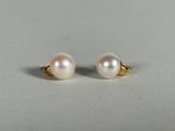 a pair of pearl earrings on a white surface