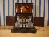 a wooden table topped with glasses and a wooden box