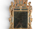 un miroir avec un cadre doré sur un mur blanc