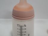 a baby bottle sitting next to a baby bottle on a table