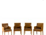 three brown leather chairs sitting next to each other on a white surface