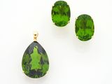 un gros plan sur une paire de boucles d'oreilles vertes et un pendentif