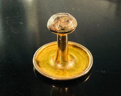 un bougeoir doré posé sur une table noire