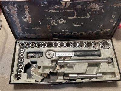 un ensemble d'outils rangés dans une boîte à outils posée par terre