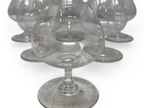 six empty wine glasses sitting on top of each other