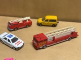quatre camions de pompiers miniatures et une voiture posés sur une table