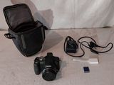 un appareil photo, un téléphone portable et un sac pour appareil photo posés par terre