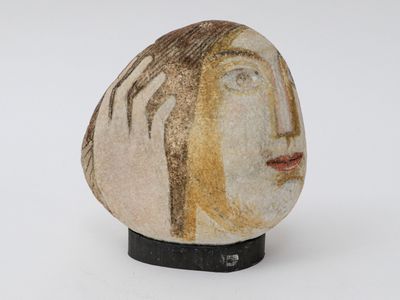 a rock with a face on it on a white surface