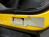 a close up of a yellow vehicle door with a sticker on it