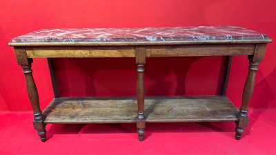 une vieille table en bois avec un plateau en marbre sur fond rouge