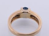 a close up of a gold ring with a sapphire stone